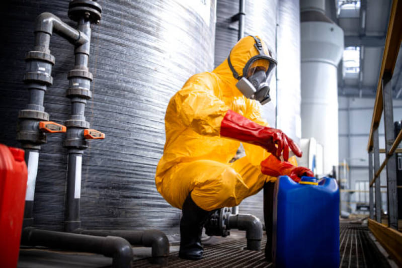Trabalhador manipulando produtos químicos, utilizando equipamentos de segurança individual (EPI)